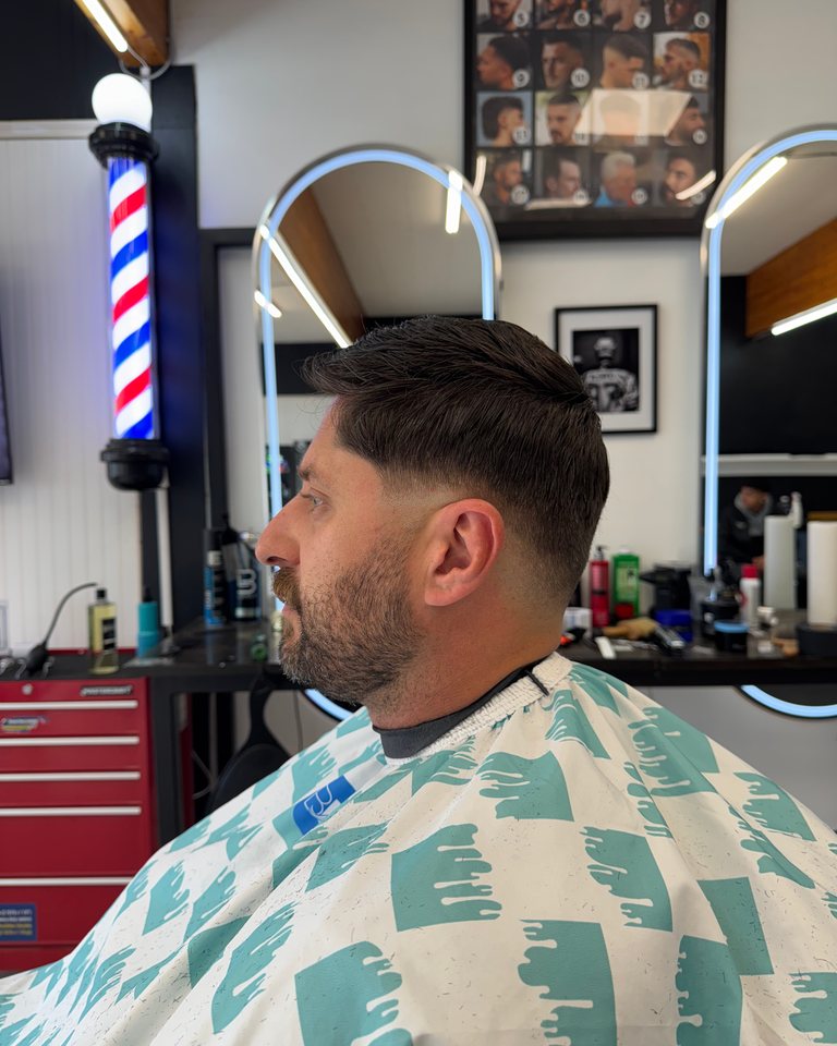 Adult fade with a shaped beard and clean edges