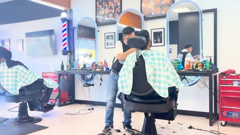 Barbers at work inside Peace River Barbershop