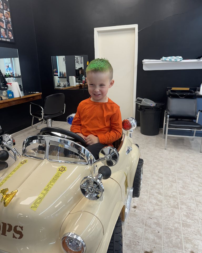 A young visitor in an orange shirt enjoying the car chair