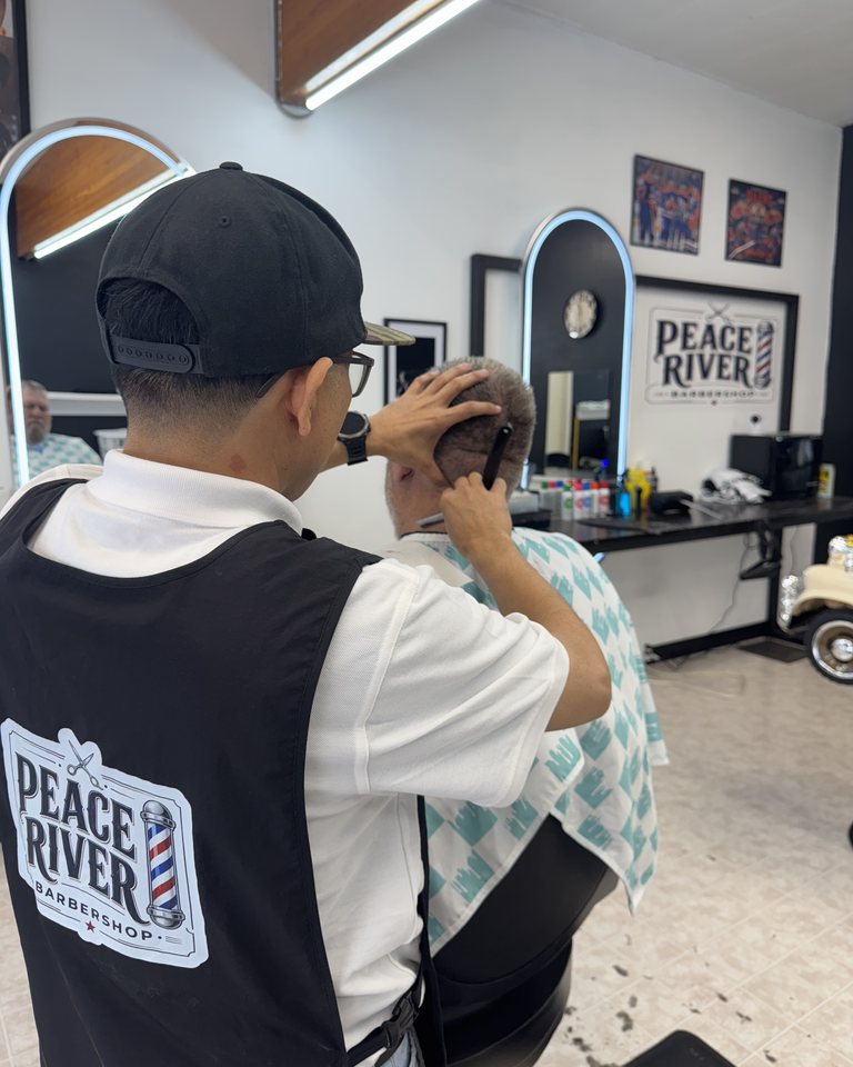 A barber working carefully on a haircut in the shop